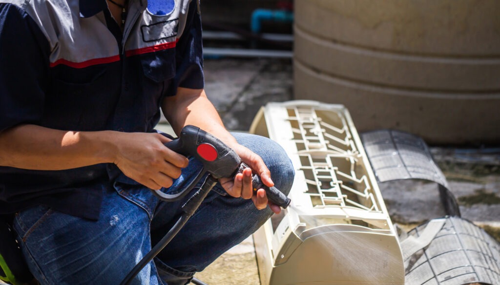 un hombre utilizando un artefacto de Tecnología para limpiar el aire acondicionado